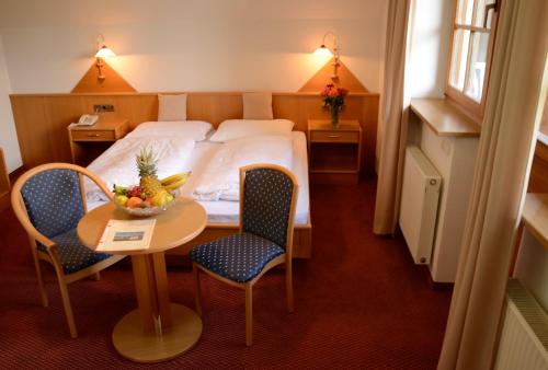 Longostagno雷斯腾纳霍夫酒店的酒店客房带一张床、一张桌子和椅子