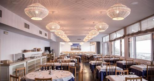 圣卡洛斯拉腊皮塔卡洛斯三世酒店的用餐室配有桌椅和灯光