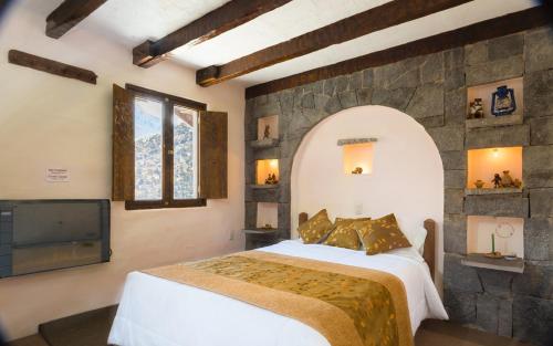 奇瓦伊Pozo del Cielo的一间卧室设有一张大床和石墙