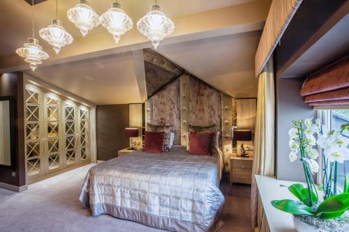 Walmersley红厅酒店的一间卧室配有一张大床和吊灯。