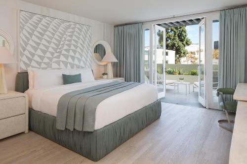 洛杉矶Avalon Hotel Beverly Hills, a Member of Design Hotels的一间带大床的卧室和一个阳台