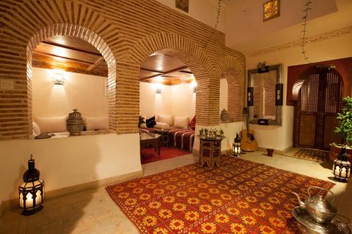 马拉喀什本萨利赫摩洛哥传统庭院住宅的带沙发的客厅和带地毯的房间