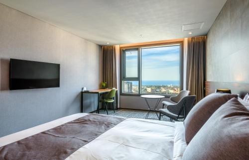 济州市济州酒店的酒店客房设有一张床和一个大窗户