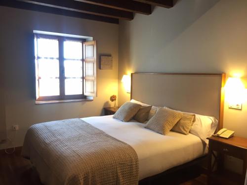 维多利亚-加斯特伊兹厄尔库托酒店及餐厅的一间卧室设有一张大床和窗户