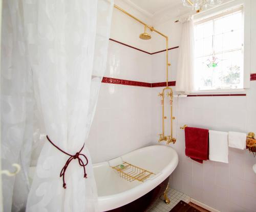 布罗肯希尔艾拉度假屋的白色的浴室设有浴缸和窗户。