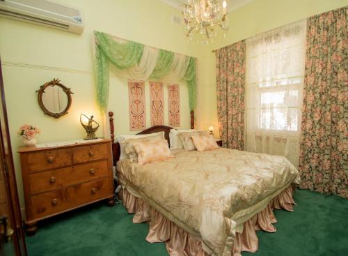 布罗肯希尔艾拉度假屋的一间卧室配有一张床、一个梳妆台和一扇窗户。