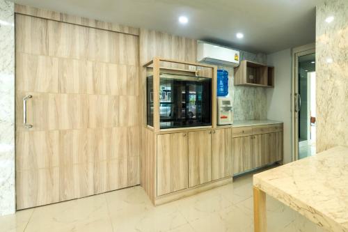 坤敬Supreme Place SHA Plus的一个带木制橱柜和柜台的厨房
