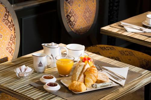 巴黎伟人酒店的桌上的早餐盘包括羊角面包和橙汁