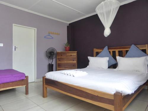 卢萨卡纳特汪齐背包客旅舍的一间卧室配有一张带蓝色和白色枕头的床