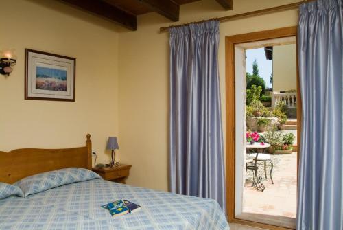 圣玛加利达Son Flor Agroturisme的一间卧室设有一张床和一个滑动玻璃门