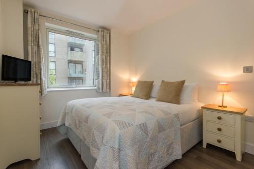 剑桥米尔公园城市住宿公寓的白色的卧室设有床和窗户