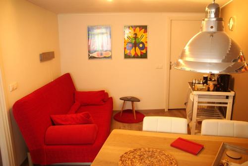 埃尔默洛Bed and Breakfast de Verwennerij的客厅配有红色的沙发和桌子