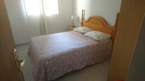 穆尔西亚Apartment La Huerta de Beniajan 50 por ciento dcto directo的一间卧室配有一张带木制床头板的床