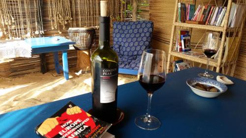 KetaA&Y Wild Camp Ghana的一瓶葡萄酒和一张桌子上的一杯