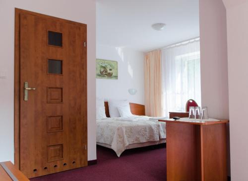 鲁恰内尼达尼兹奇酒店的一间卧室配有一张床和一扇木门