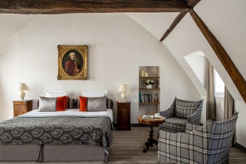 巴黎Hôtel d'Orsay - Esprit de France的一间卧室配有一张特大号床和一把椅子