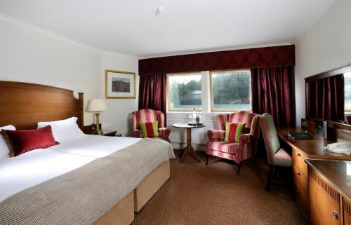 福尔柯克麦克唐纳德伊奇拉度假酒店&SPA的酒店客房,配有一张床、一张桌子和椅子