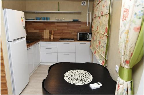 卡拉甘达Apartment on Pichugina的一间带桌子和白色冰箱的小厨房