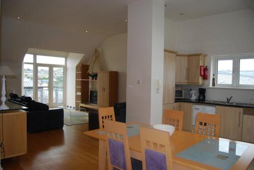 金塞尔Harbour View Apartment Kinsale的厨房以及带桌椅的起居室。