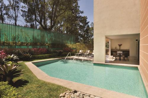 圣何塞圣何塞皮纳雷斯凯悦广场酒店的一座房子的院子内的游泳池