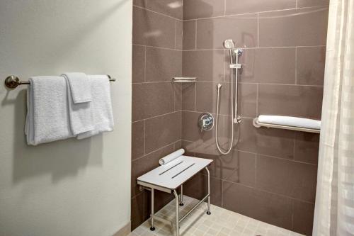 谢尔顿谢尔顿凯悦豪斯酒店的带淋浴的浴室,配有凳子