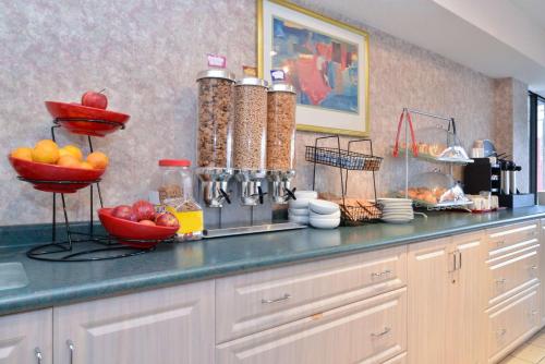 温莎Lexington Inn & Suites-Windsor的厨房里有一个柜台,上面放着一碗水果