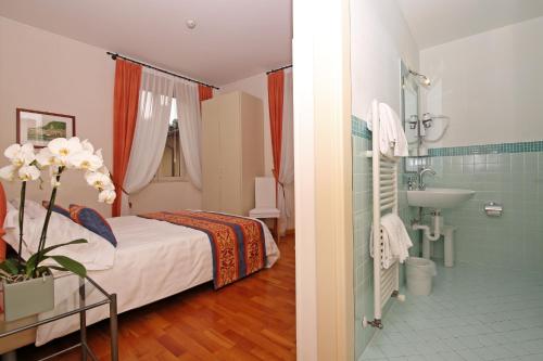 贝拉吉奥贝拉吉欧酒店的一间卧室配有一张床,浴室设有水槽