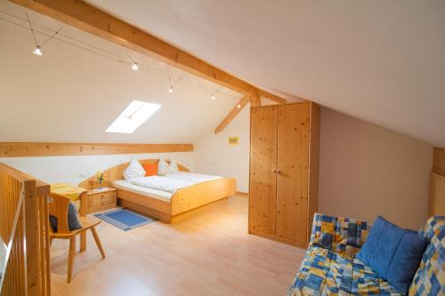 卡尔达罗St. Josefhof的阁楼卧室配有1张床和1张沙发