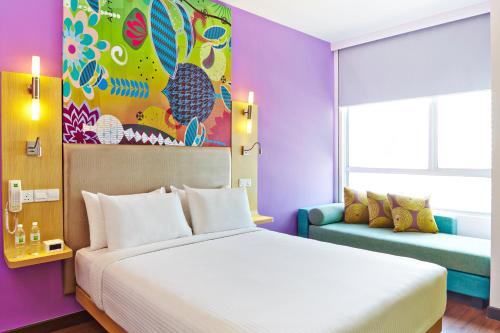 吉隆坡吉隆坡宜必思尚品弗拉斯尔商务园酒店的一间卧室配有一张大床和一张沙发