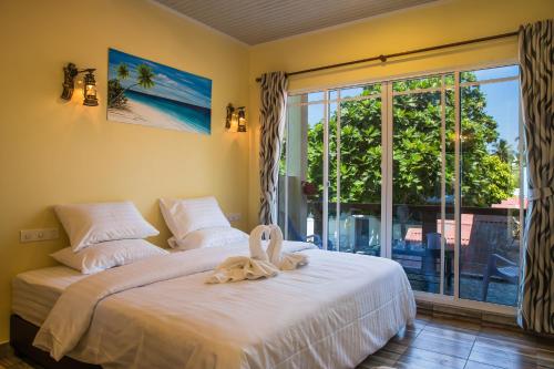 图杜马尔代夫托多轻松旅馆的一间卧室配有一张床,床上有毛巾