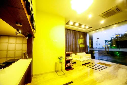 德瓦纳哈利-班加罗尔微风套房酒店的黄色的客厅配有沙发和椅子