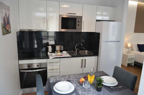 丰沙尔Edificio Charles 103的厨房配有白色橱柜和一张桌子
