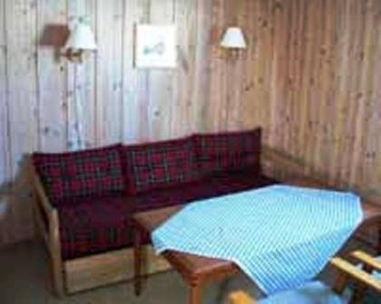 高尔卡万胡德旅游中心酒店的客厅配有红色的沙发和桌子