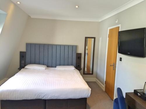 伦敦花园府酒店的一间卧室配有一张大床和一台平面电视