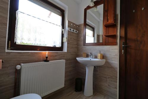 锡比乌Casa 193的一间带水槽的浴室和一个带蜡烛的窗户