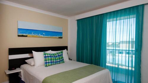 AltagraciaLD Suites Punta Playa的一间卧室设有一张床和一个大窗户