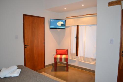 蒂尔卡拉Al Sereno Hotel Panoramico的卧室配有红色椅子和墙上的电视