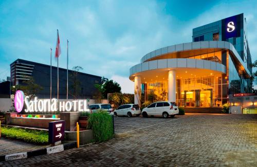 日惹Satoria Hotel Yogyakarta - CHSE Certified的一辆汽车停在大楼前的酒店