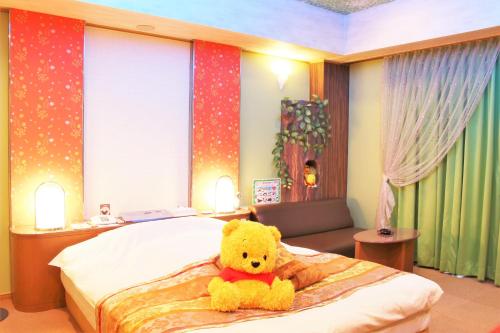 大分Hotel Pal Furugou (Love Hotel)的坐在床上的黄泰迪熊