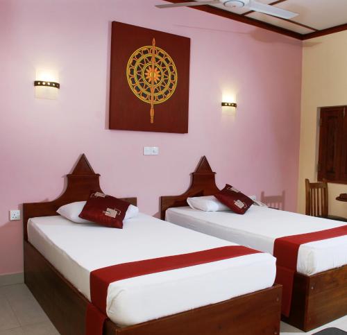 阿努拉德普勒The Triangle Hotel的墙上画画的房间里设有两张床