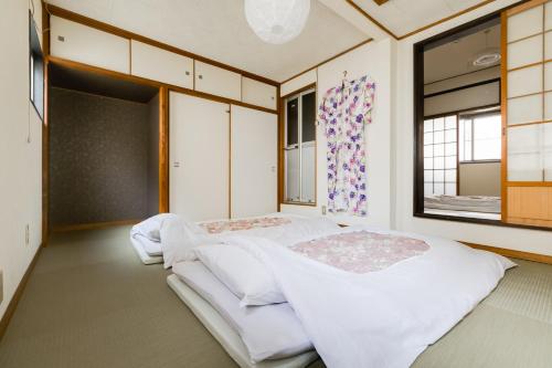 大阪雪家度假屋的带2扇窗户的客房内的2张床