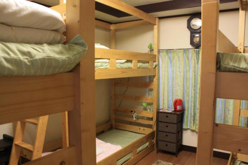 青梅市Guesthouse Seiryu Kibako的带时钟的客房内的两张双层床