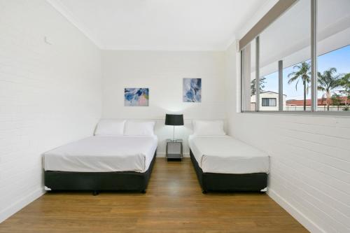 班克斯镇澳大利亚社区村庄旅馆的白色客房的两张床,设有两扇窗户