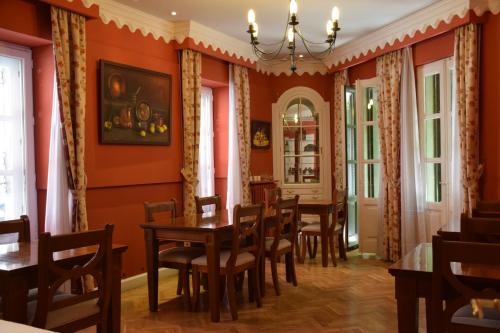 圣洛伦索-德埃斯科里亚尔普萨达多恩海姆酒店的用餐室设有橙色墙壁和木桌及椅子