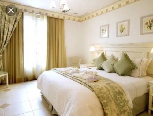 弗洛里亚诺波利斯Il Campanario Villaggio room的卧室配有带绿色枕头的大型白色床