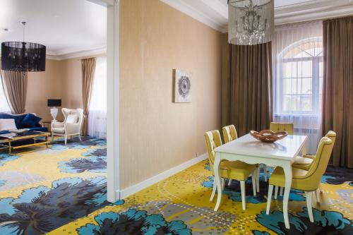 阿斯塔纳阿斯塔纳ONE酒店的一间设有白色桌子和黄色椅子的用餐室