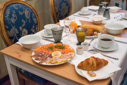 欧村Ault - Villa Aultia Hotel - baie de somme的一张桌子,上面放着一盘食物和羊角面包