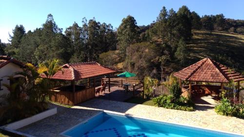 库尼亚Pousada Colar de Ouro的一座带游泳池和两个凉亭的房子