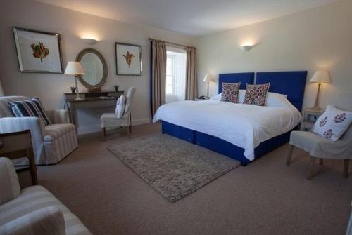 Bridgend布里真德酒店的一间卧室配有一张床、一把椅子和镜子