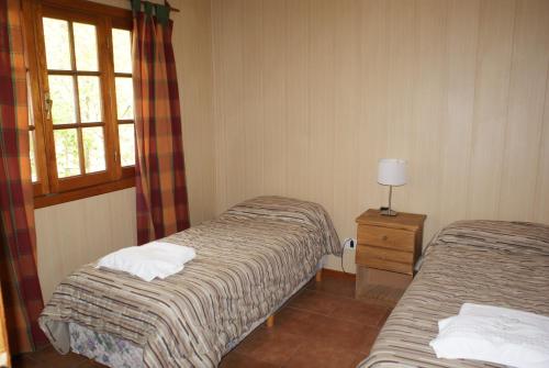 埃尔卡拉法特埃尔蓬特公寓酒店的酒店客房设有两张床和窗户。
